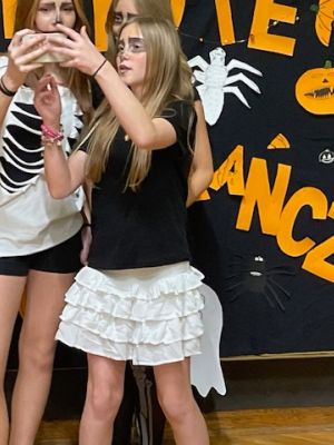 Uczestnicy dyskoteki robią sobie zdjęcie na ściance.