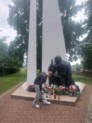 Uczeń klasy 8c zapala znicz pod pomnikiem bohaterów II wojny światowej w Koźlu.