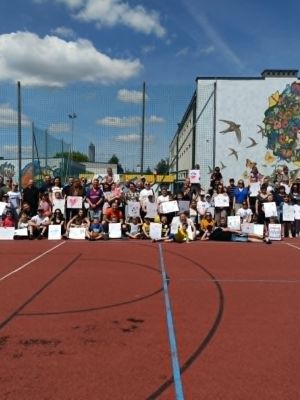 Uczniowie klas pierwszych z rodzicami na wsp&oacute;lnym pamiątkowym zdjęciu.