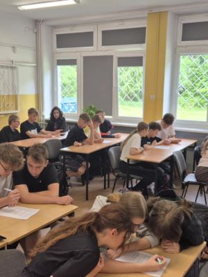 Uczniowie piszący test sprawdzający wiedzę z zakresu pierwszej pomocy i zasad ochrony przeciwpożarowej.