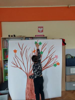 przyklejanie liści do drzewa przez uczni&oacute;w