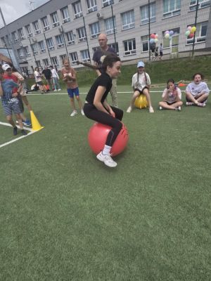 Uczeń pokonujący slalom z piłka.