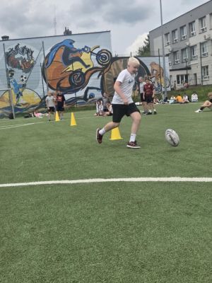Uczeń pokonujący slalom z piłka.