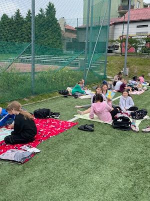 Uczniowie klasy 3b korzystają z pięknej pogody, bawiąc się wspólnie na kocykach.