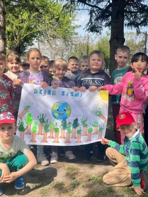 uczniowie oddzialu przedszkolnego prezentuja plakat zwiazany z dniem ziemi