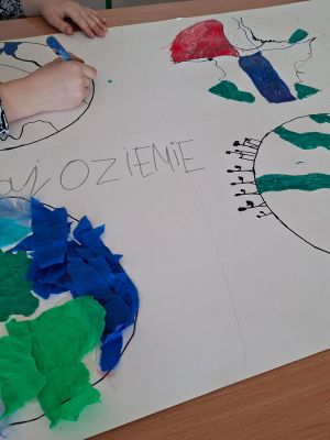 Czwartoklasiści wykonują plakaty ekologiczne z okazji Dnia Ziemi.