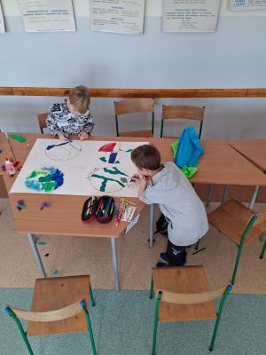 Czwartoklasiści wykonują plakaty ekologiczne z okazji Dnia Ziemi.