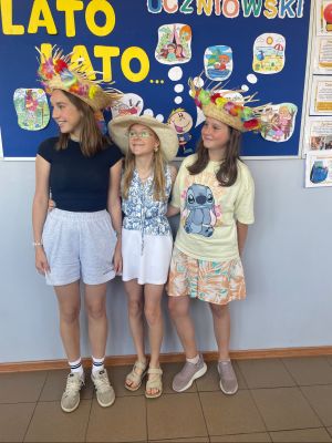 Uczennice stoją na tle gazetki z napisami Lato.
