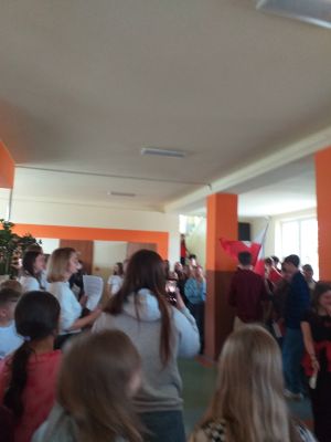  Inscenizacja manifestacji robotniczej. Uczniowie klas &oacute;smych skandują hasła i machają flagami Polski i UE.