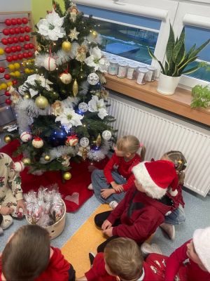 Klasa 1b śpiewa piosenki przy choince w mikołajkowym nastroju i odbiera prezenciki od Mikołaja.