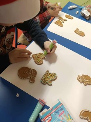 Uczeń z klasy 1a dekoruje pierniki.