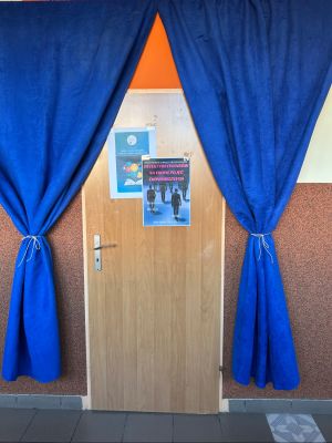 Wejście do pracowni zdobi plakat reklamujący lekcję.