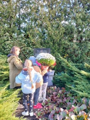 Uczniowie składają kwiaty i zapalają znicze na Cmentarzu Rzymskokatolickim w Strykowie.