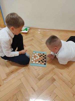 Uczniowie grają w swoje gry planszowe.