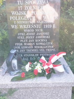 Wiązanka biało - czerwonych kwiat&oacute;w złożona na grobie żołnierzy Września 1939 roku pochowanych na cmentarzu rzymskokatolickim w Strykowie
