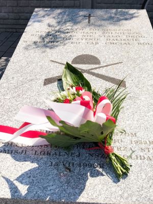 Wiązanka biało - czerwonych kwiat&oacute;w złożona na grobie żołnierzy Września 1939 roku pochowanych na cmentarzu mariawickim w Strykowie 