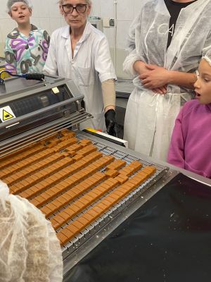 Uczniowie klas drugich obserwują proces produkcji cukierków 